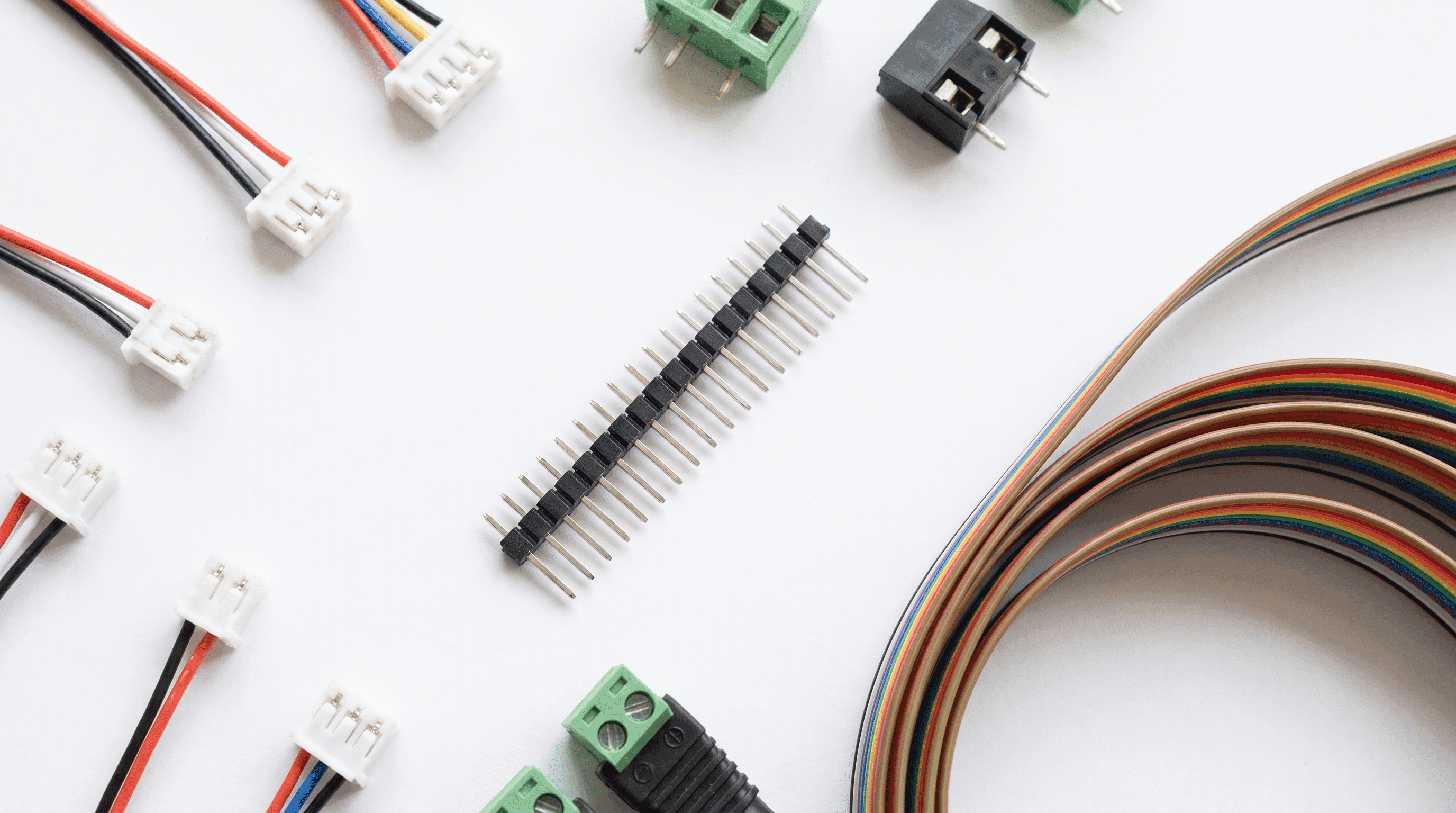 Flat-lay of JST connectors, pin headers, terminal blocks and ribbon cable