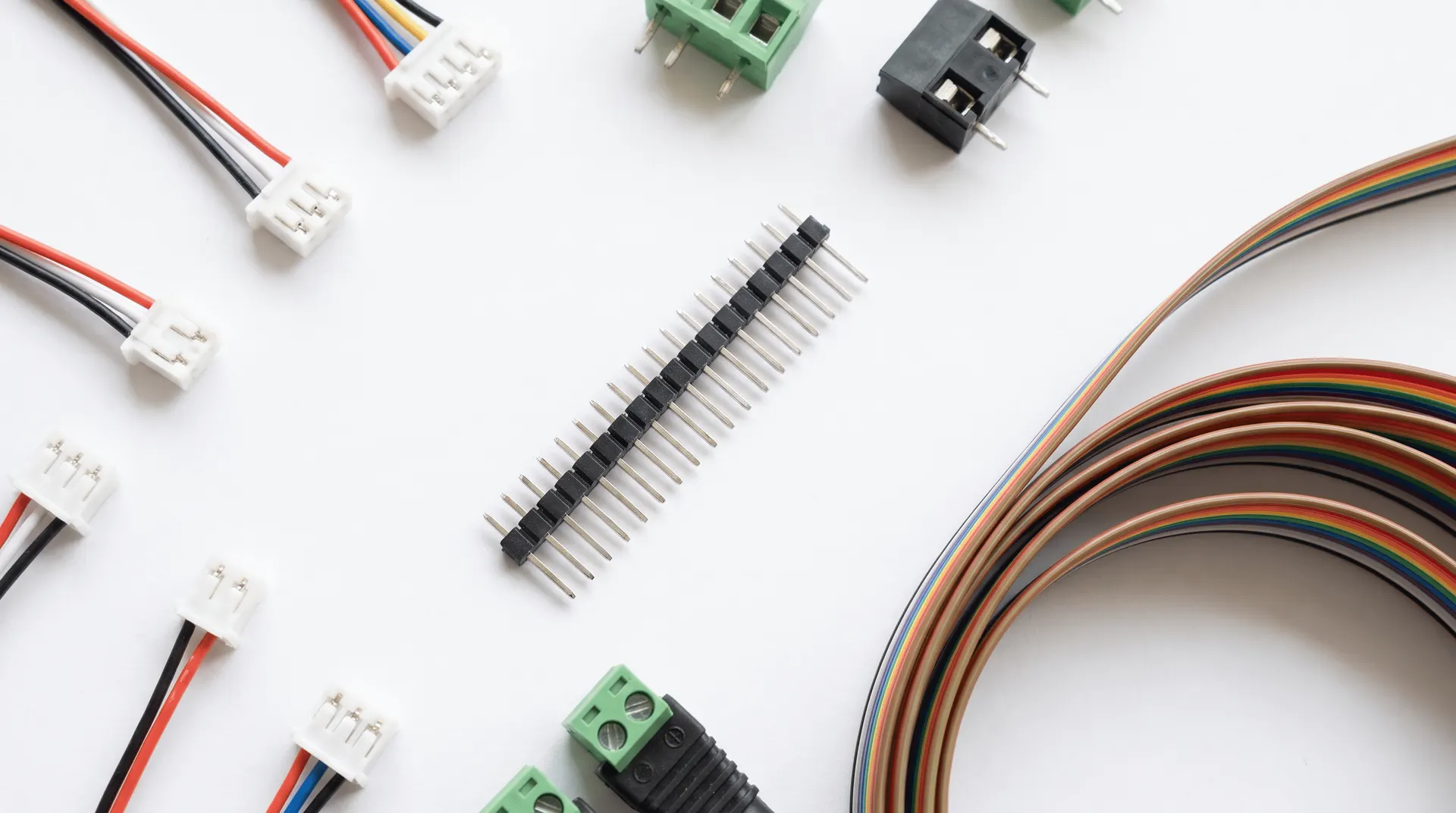 Flat-lay of JST connectors, pin headers, terminal blocks and ribbon cable